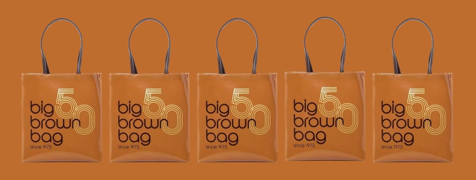 Bloomingdale's brown bag and identity system — the Vignelli condensed Helvetica logotype on dark kraft paper