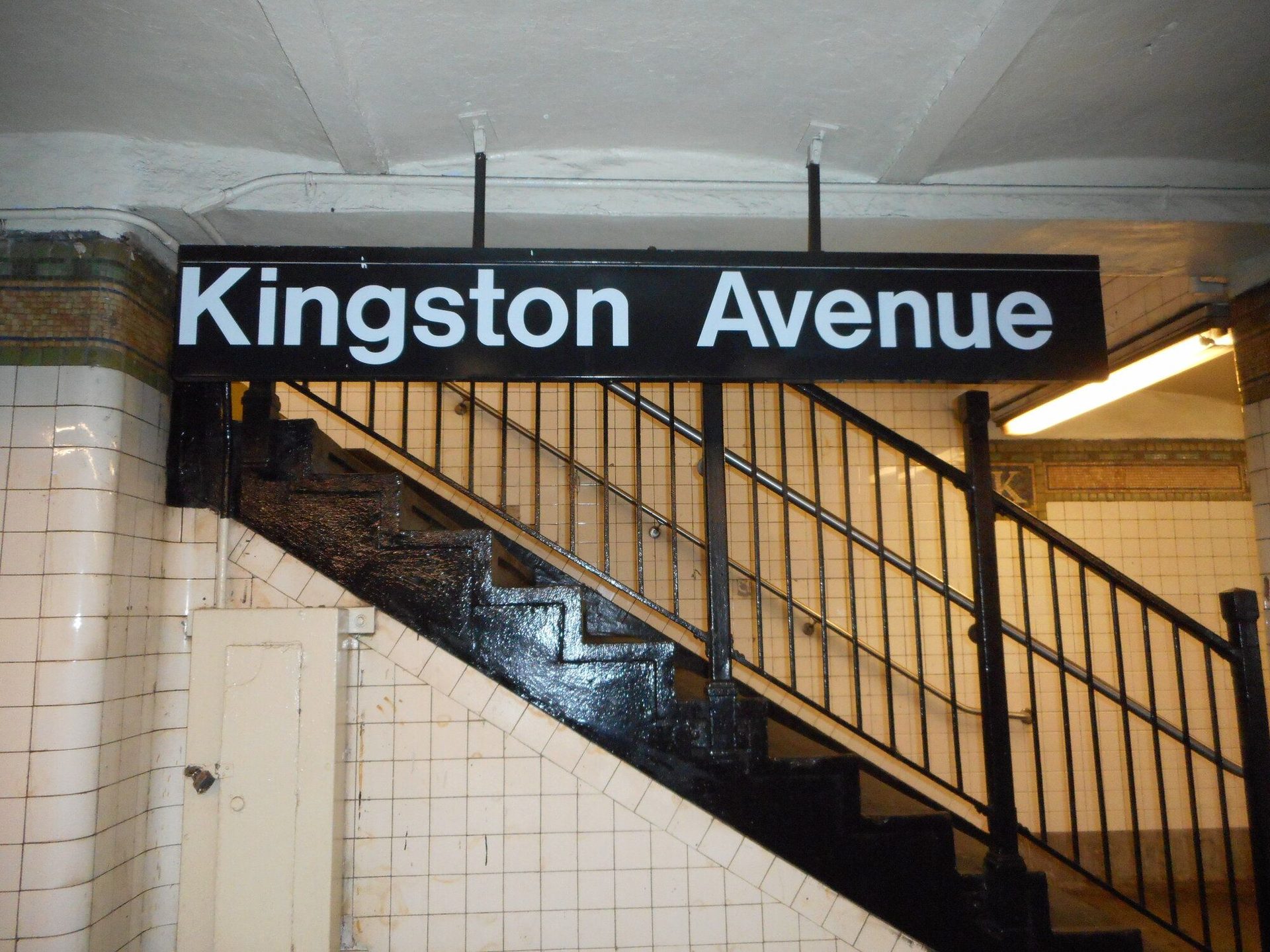 MTA Helvetica station sign hanging from ceiling, Kingston Avenue IRT station, Brooklyn